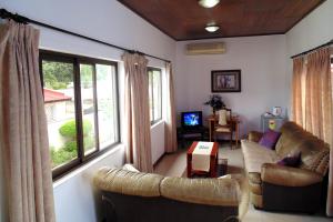 a living room with couches and a large window at Lavender Lodge Hotel in Accra
