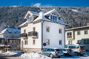 a large white house with cars parked in front of it at Chalet Embacher by AlpenTravel in Bad Gastein
