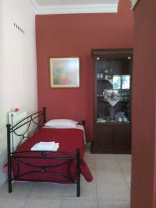 a bedroom with a red wall with a bed in it at Villa Eleni in Áfra