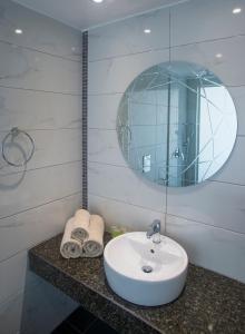 a bathroom with a sink and a mirror at Freij Beach Hotel Adults Only in Ayia Napa