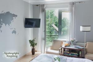sala de estar con cama y ventana en Agroturystyka Karpińscy, en Wizna