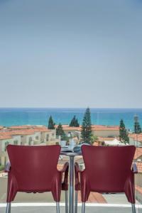 a table and chairs on a balcony with a view of the ocean at Freij Beach Hotel Adults Only in Ayia Napa