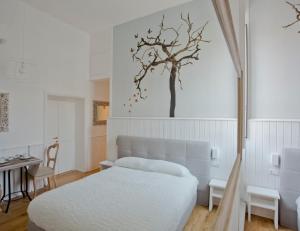 a bedroom with a bed and a tree on the wall at Primo Piano Suites in Rome