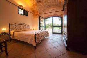 um quarto com uma cama e uma porta aberta em Masseria Fracchicchi em Galatina