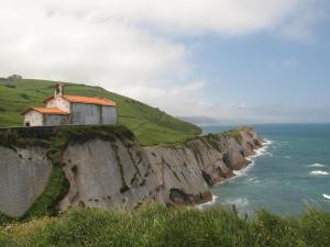 a building on a cliff next to the ocean at Apartamento Loiola in Azpeitia