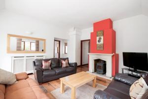 a living room with a couch and a fireplace at Old Sheepcote in Broadway