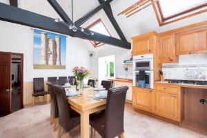 a kitchen and dining room with a wooden table and chairs at Old Sheepcote in Broadway