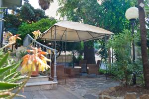 eine Terrasse mit einem Sonnenschirm, einem Tisch und Stühlen in der Unterkunft Hotel Liberty in Sanremo