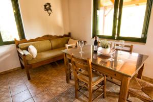 a dining room with a table and a couch at Villas Paleochora in Palaiochóra