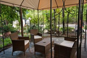eine Terrasse mit einem Tisch, Stühlen und einem Sonnenschirm in der Unterkunft Hotel Liberty in Sanremo