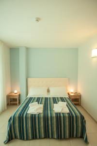 シルヴィ・マリーナにあるHotel Rivieraのベッドルーム1室(大型ベッド1台、タオル2枚付)