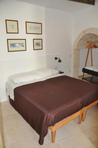 プティニャーノにあるPorta Barsentoのベッドサイドサイドサイドサイドサイドサイド付きの白い部屋のベッド1台