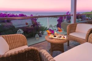 a balcony with chairs and a table with food on it at Hotel Dei Pini in Alghero