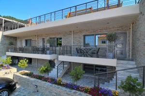 a house with a balcony and a patio at Ntinas Filoxenia Hotel & Spa in Skala Potamias