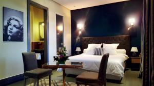 a bedroom with a bed and a table and chairs at Le Sphinx Boutique H&ocirc;tel in Mohammedia