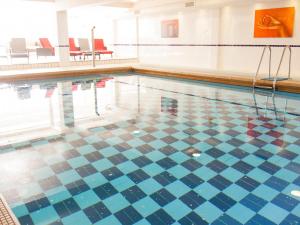 a swimming pool with a tiled floor at Sandbanks Hotel in Poole