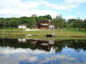 a house sitting on the side of a lake at Lieux-au-lac in Augignac