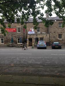 un edificio con un coche aparcado delante de él en Red Lion Inn, en Newbrough