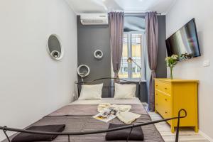 a bedroom with a bed with a yellow dresser and a tv at Main Square studios in Rijeka