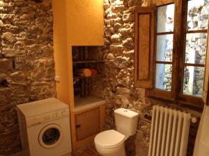 Un baño con inodoro y lavadora. en Ca la iaia Veva, en Sant Joan les Fonts 37 fotos más