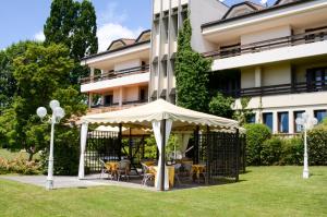 un kiosque avec des tables et des chaises en face d'un bâtiment dans l'établissement Hotel Bellavista, à Montebelluna