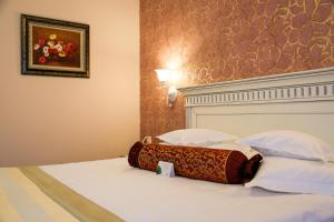 a hotel room with a bed with two pillows at Hotel Foisorul cu Flori in Sinaia