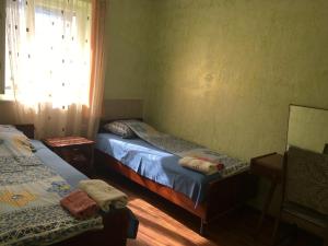 1 dormitorio con 2 camas individuales y ventana en Guest House GarniResthost, en Garni