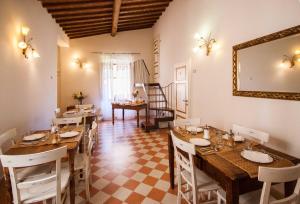 uma sala de jantar com mesas e cadeiras e um espelho em A Casa Mastacchi em Siena