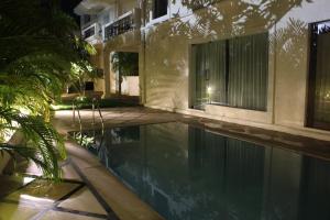 a swimming pool in front of a house at night at Mansions by Pinto Rosario in Bastora