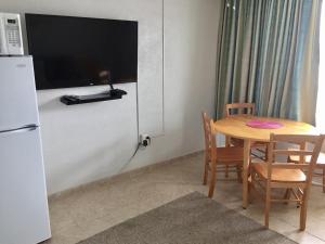 a kitchen with a table and a television and a table and chairs at Lollipop Motel in North Wildwood