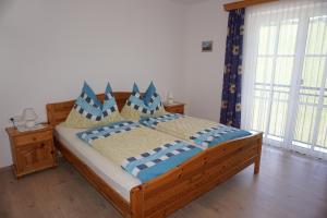 1 dormitorio con cama de madera y almohadas azules en Ferienwohnung Hausleitner, en Zell am Moos