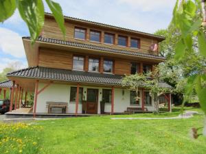 a wooden house with a lawn in front of it at Qi Gong Haus in Roßdorf