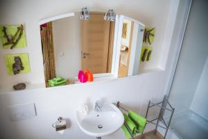 ein Badezimmer mit Waschbecken und Spiegel in der Unterkunft Qi Gong Haus in Roßdorf