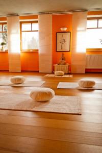 Zimmer mit Matten auf einem Holzboden mit Fenstern in der Unterkunft Qi Gong Haus in Roßdorf