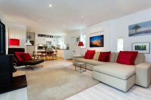 a living room with a couch and red pillows at Veeve - Camden Mews Terrace in London