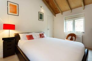 ロンドンにあるVeeve - Camden Mews Terraceのベッドルーム(白いベッド1台、赤いランプ付)