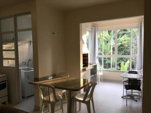 a kitchen with a table and chairs and a window at Pousada e Camping Lagoa da Conceição in Florianópolis