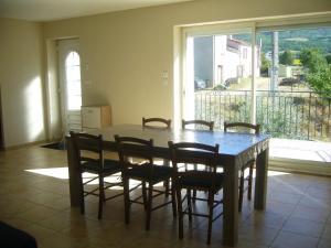 comedor con mesa, sillas y ventana en Maison de Campagne aux deux Oliviers, en Ribiers