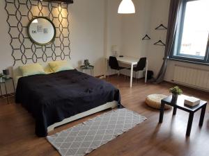 a bedroom with a bed and a table and a mirror at 27 Shades of Green (4 bedroom 3 Bath Sunny Central) in Budapest