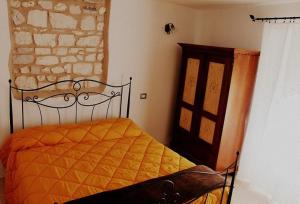 1 dormitorio con 1 cama y armario de madera en Casa Vacanze L'arco di Fondarca, en Cagli