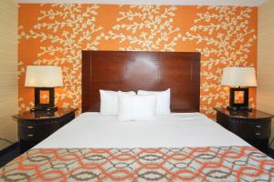 a hotel room with a bed and two lamps at Corona Hotel New York - LaGuardia Airport in Queens