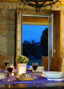 a table with glasses of wine on it with a window at Casa da Torre in Pico