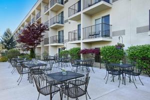 a group of tables and chairs in front of a building at Oxford Suites Yakima in Yakima