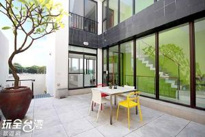 a house with a table and chairs and a tree at Tainan Anping - Shuiau 180 in Anping