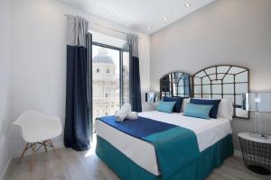 - une chambre avec un grand lit et une fenêtre dans l'établissement BiBo Suites Gran Vía, à Grenade