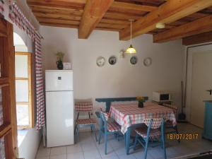 a kitchen with a table and chairs and a refrigerator at Molnárporta in Szentgyörgyvölgy