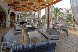 un patio al aire libre con sillas, mesas y sillas en Aparthotel Paladim & Alagoamar, en Albufeira