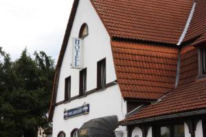 ein weißes Gebäude mit einem Schild an der Seite in der Unterkunft Hotel Zum goldenen Stern in Leibsch