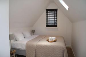 a white bedroom with a bed and a window at Koningshof in Alkmaar