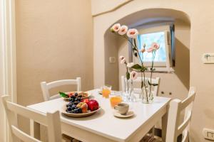 a table with a plate of fruit and flowers on it at Borgo San Gaetano in Bernalda